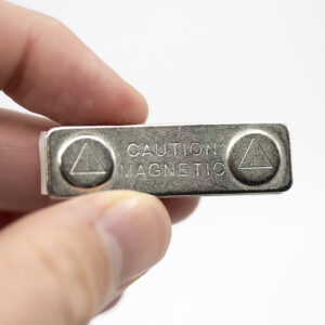 Strong magnetic name badge fastener with caution magnetic warning held in hand